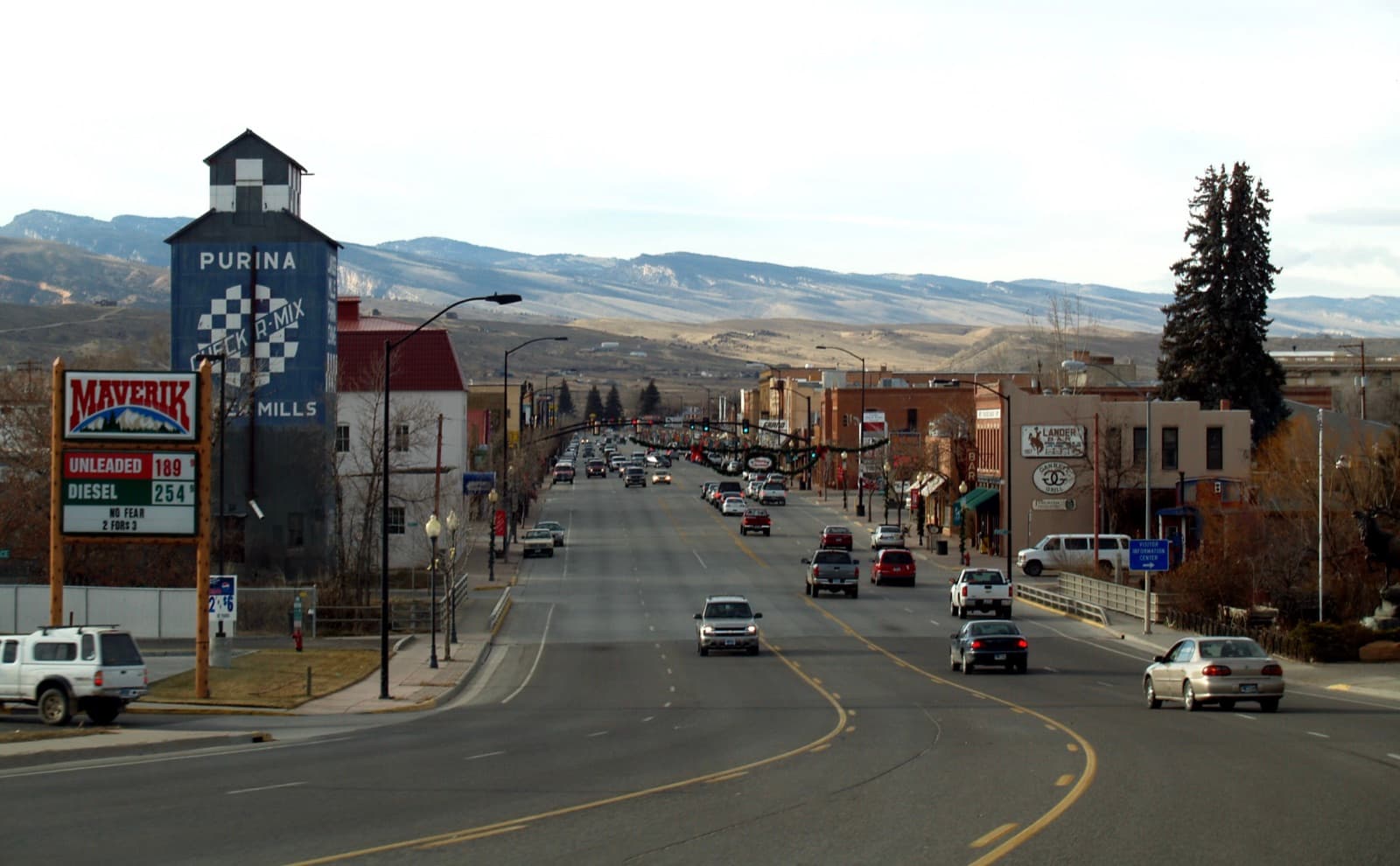 View down Lander, Wyoming's Main Street — the historic Purina Mills elevator and downtown storefronts with the Wind River Range foothills rising behind town